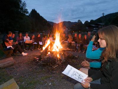 Schulgruppe singt am Lagerfeuer beim Jugendferienhaus in Saalbach
